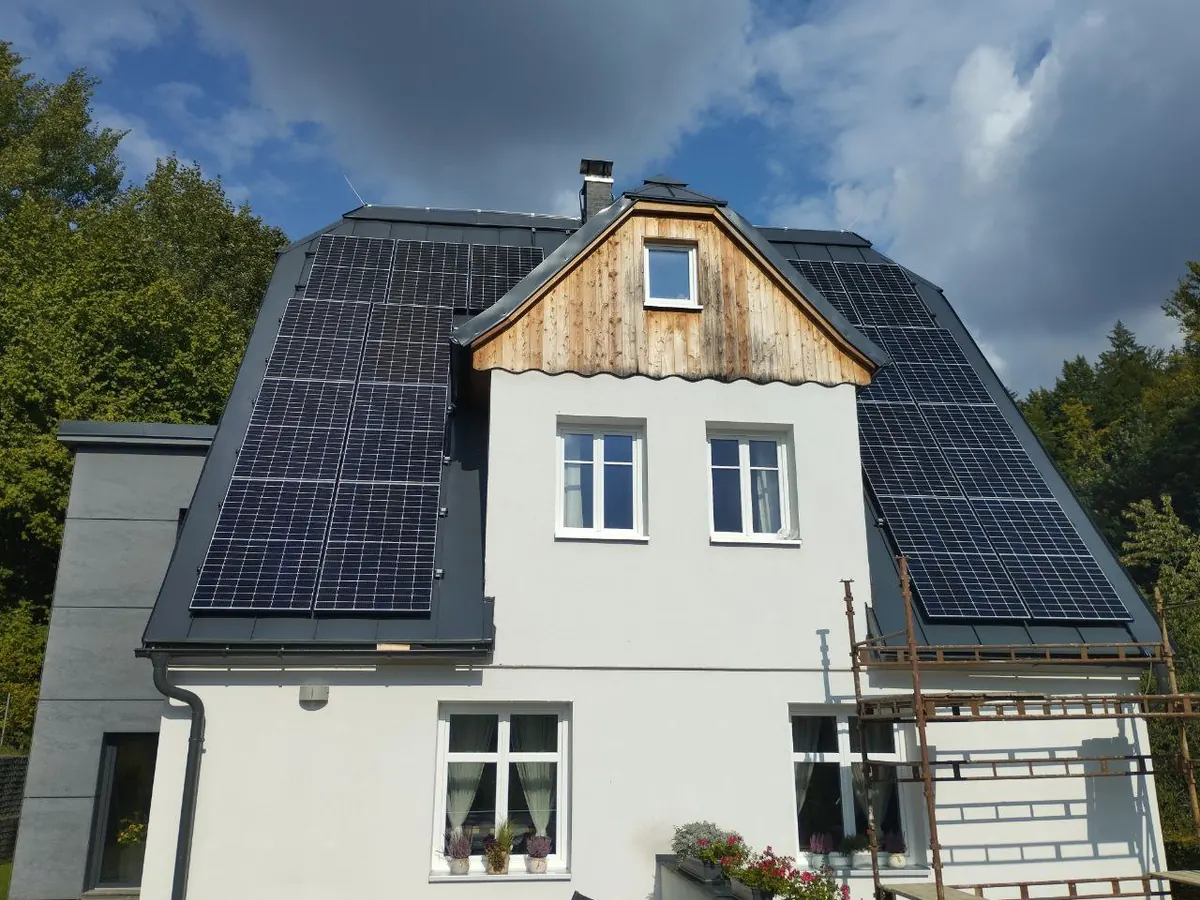 Rodinný dům s fotovoltaickými panely na tmavé střeše